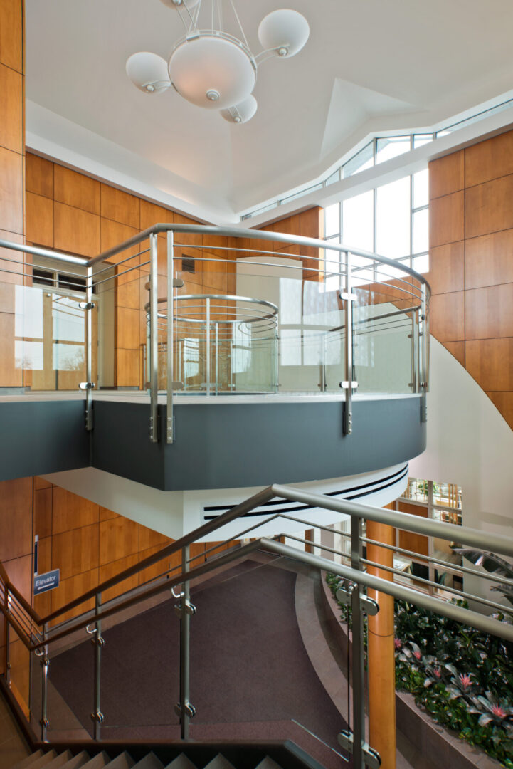 A glass staircase with metal railing in the middle of it.