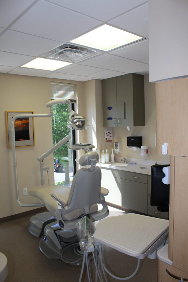A dentist 's office with a chair and sink.